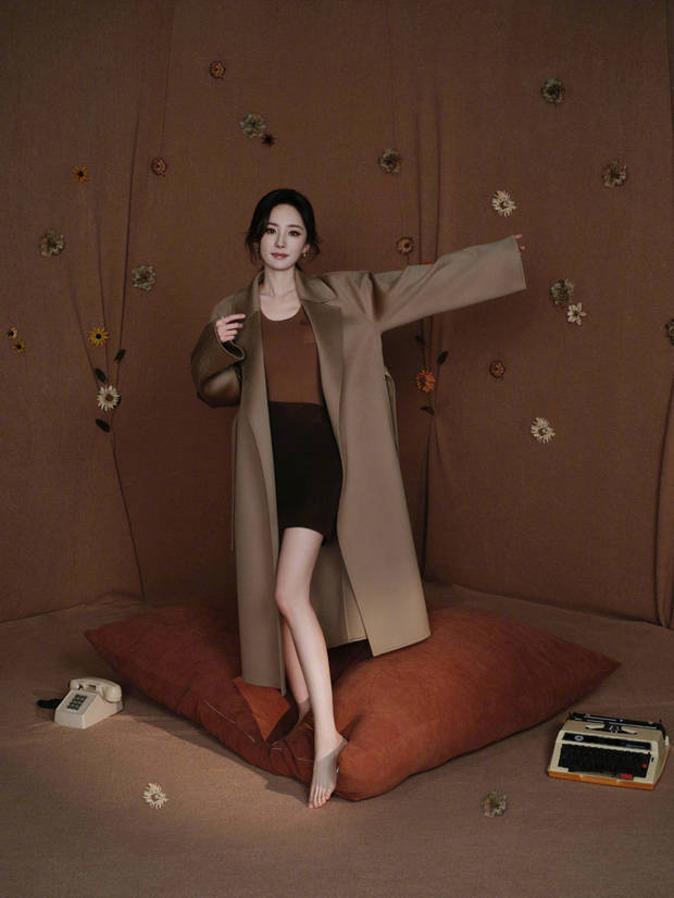 搜狐娱乐讯 30日，杨幂参加活动的造型美照释出，她身着驼色大衣气质温柔，大方秀纤细美腿，颜值养眼！