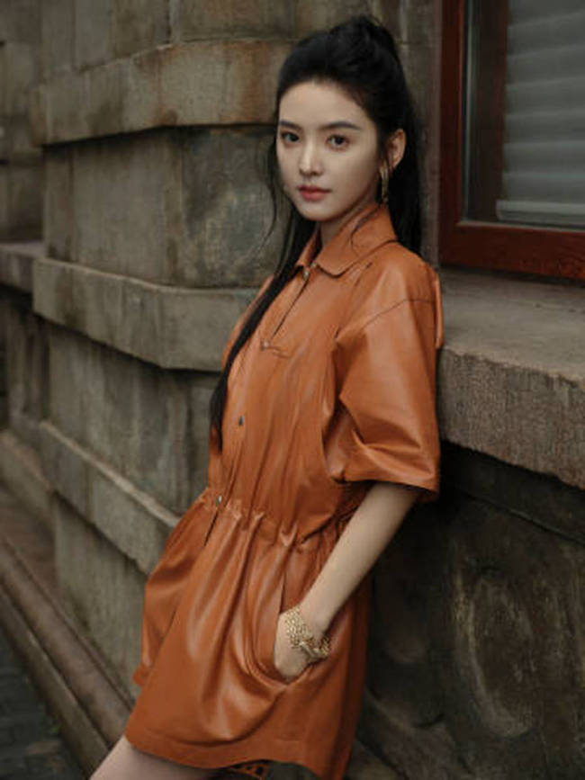 章若楠穿橘色皮裙漫步上海 手撑雨伞步伐轻盈灵动